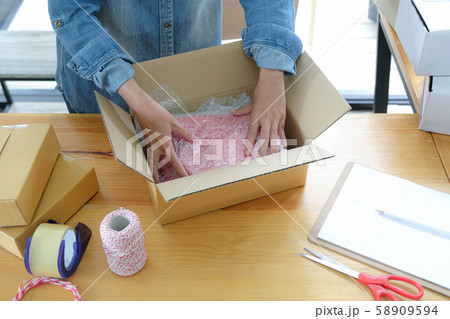 Online sellers are packing products into boxes for shipping to customers. 58909594