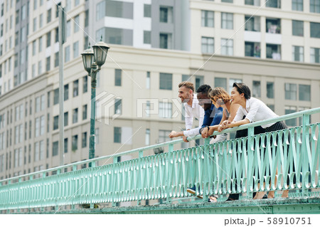 Happy coworkers standing on bridge 58910751