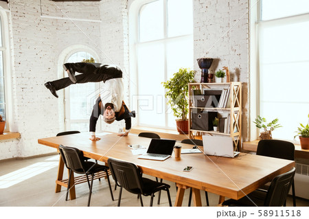 Businessman having fun dancing break dance in the office at work Businessman having fun dancing break dance in the office at work 58911518