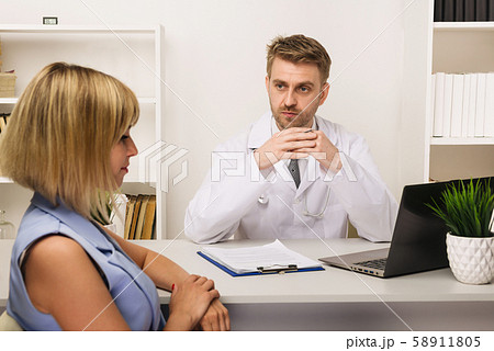 Young woman on a consultation with a male surgeon 58911805