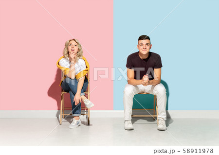 Young emotional man and woman on pink and blue background Young emotional man and woman on pink and blue background 58911978