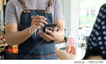Employee holding a smartphone to save the menu the customer order. Employee holding a smartphone to save the menu the customer order. 58912396