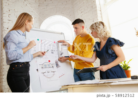 Interior designer working with young couple. Lovely family and professional designer or architector. 58912512