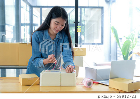 Teenage girls are packing the products in the box 58912723