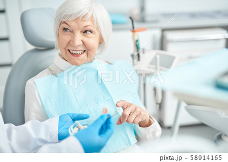 Senior lady asking questions about dental dentures 58914165
