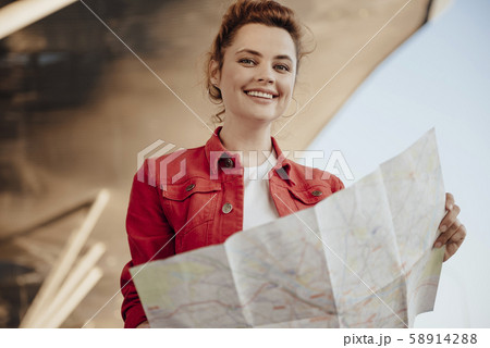 Smiling girl with map outdoors stock photo Smiling girl with map outdoors stock photo 58914288