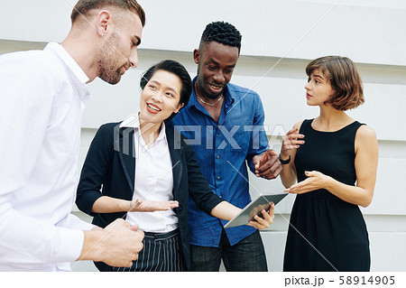 Business people discussing document on tablet Business people discussing document on tablet 58914905