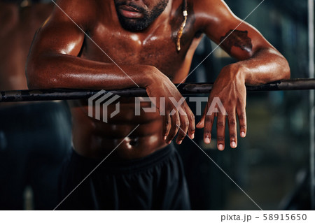 Sweaty man leaning on railing 58915650