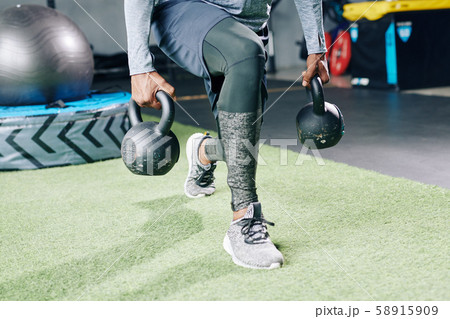 Sportsman doing weight lunges Sportsman doing weight lunges 58915909