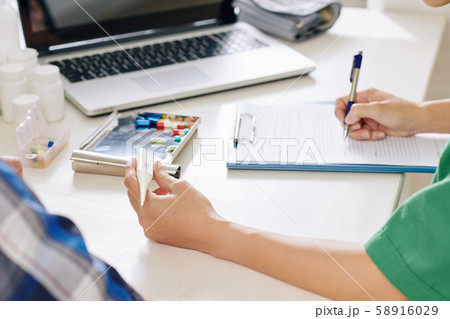 Nurse filling medical card of senior patient Nurse filling medical card of senior patient 58916029