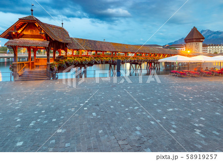 Lucerne. The famous Chapel, Kapellbrucke bridge at dawn in night lighting. 58919257
