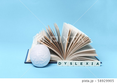 Dyslexia word book and brain on blue with copy 58929905