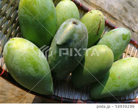 green mango on basket and old wooden desk ,group green mango on basket and old wooden desk ,group 58930286