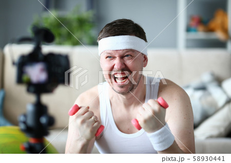 Vlogger with Happy Face Holding Dumbbells in Hands Vlogger with Happy Face Holding Dumbbells in Hands 58930441