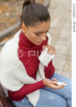 Ill woman thinking of taking her medicine 58934315