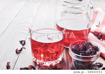Closeup view at glass of hibiscus ice tea and jug 58934551