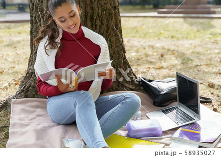Beautiful cheerful student working on her homework Beautiful cheerful student working on her homework 58935027