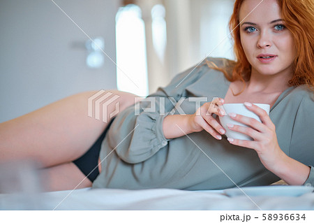 Beautiful girl at her bedroom drinking tea in the 58936634