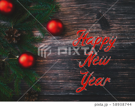 inscription Happy New Year on a wooden background with fir branches and red balls inscription Happy New Year on a wooden background with fir branches and red balls 58938744