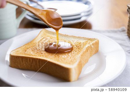 トーストにマヌカハニーを塗る トーストにマヌカハニーを塗る 58940109