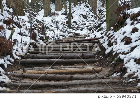 積雪とぬかるんだ道を進む階段道 58940571