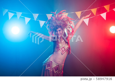 Carnival, belly dance and holiday concept - Beautiful female samba dancer wearing gold costume and Carnival, belly dance and holiday concept - Beautiful female samba dancer wearing gold costume and 58947916