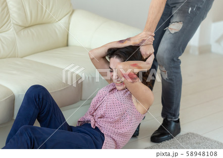 domestic violence, victim and abuse concept - cruel aggressive man grabbing his wife lying on the 58948108