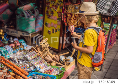 Boy at a market in Ubud, Bali. Typical souvenir shop selling souvenirs and handicrafts of Bali at Boy at a market in Ubud, Bali. Typical souvenir shop selling souvenirs and handicrafts of Bali at 58948369