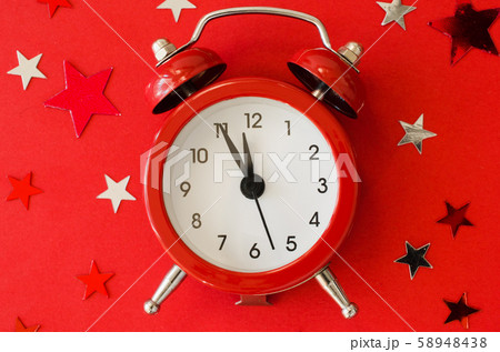 Festive Christmas background with alarm clock on red background in minimal style. Festive Christmas background with alarm clock on red background in minimal style. 58948438
