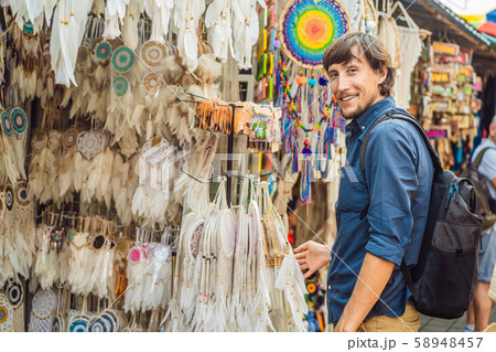 Man at a market in Ubud, Bali. Typical souvenir shop selling souvenirs and handicrafts of Bali at Man at a market in Ubud, Bali. Typical souvenir shop selling souvenirs and handicrafts of Bali at 58948457
