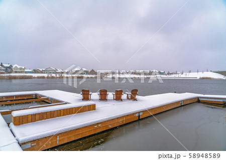 Deck with wooden chairs on a lake in Daybreak Utah 58948589