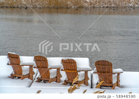 Deck on lake with wooden chairs in Daybreak Utah 58948590