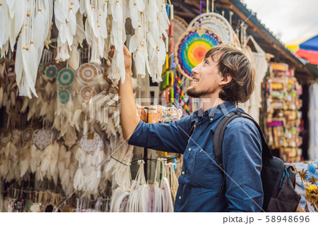Man at a market in Ubud, Bali. Typical souvenir shop selling souvenirs and handicrafts of Bali at Man at a market in Ubud, Bali. Typical souvenir shop selling souvenirs and handicrafts of Bali at 58948696