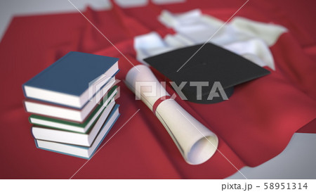 Graduation cap, books and diploma on the Swiss flag. Higher education in Switzerland related Graduation cap, books and diploma on the Swiss flag. Higher education in Switzerland related 58951314
