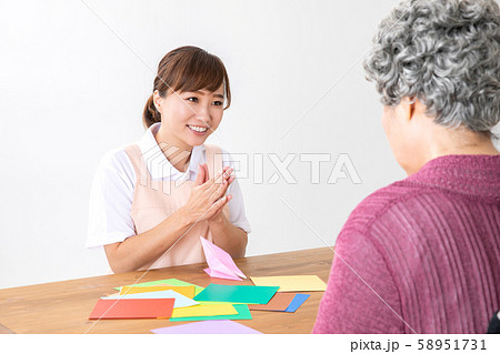 折り紙する高齢者を褒める介護士 58951731
