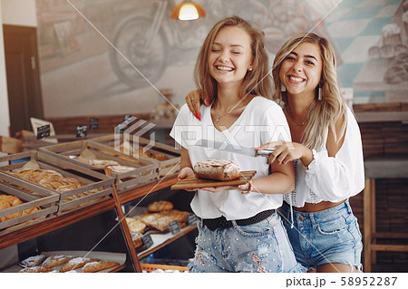 Beautiful girls buys buns at the bakery 58952287