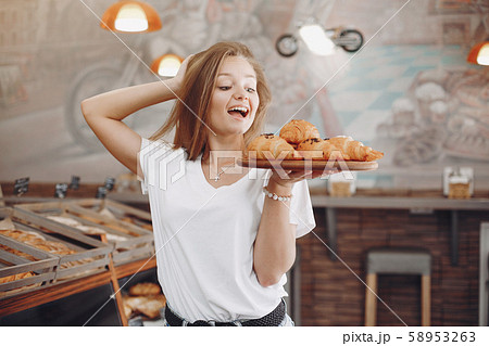Beautiful girl buys buns at the bakery 58953263