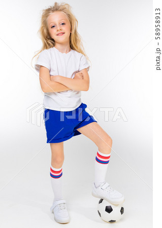 Fashion girl blonde with long hair in sports shirt, shorts, sneakers stands with soccer ball Fashion girl blonde with long hair in sports shirt, shorts, sneakers stands with soccer ball 58958913