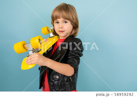 a teenage caucasian boy holds a yellow penny in hands, picture isolated on blue background a teenage caucasian boy holds a yellow penny in hands, picture isolated on blue background 58959292