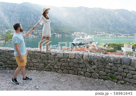 girl walking along the parapet at the fortress above Kotor, boyfriend holds her hand 58961645