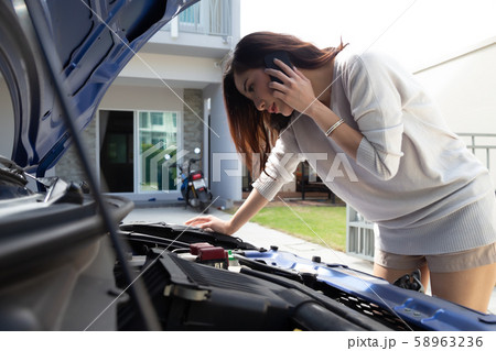 Young asian woman using mobile phone call a car 58963236