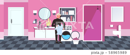 man doing housework guy loading clothes in washing machine cleaning service concept modern bathroom 58965989