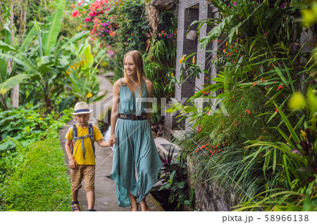 Mother and son tourists in Bali walks along the narrow cozy streets of Ubud. Bali is a popular 58966138