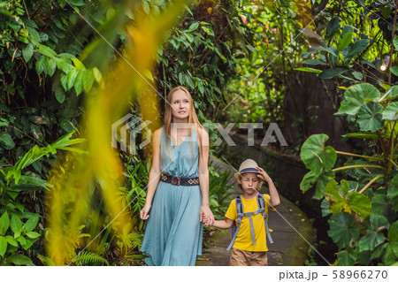 Mother and son tourists in Bali walks along the narrow cozy streets of Ubud. Bali is a popular 58966270