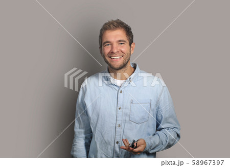 Young man in denim shirt is smiling Young man in denim shirt is smiling 58967397