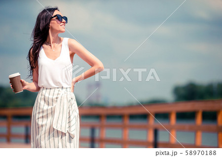 Happy young urban woman drinking coffee in european city. Happy young urban woman drinking coffee in european city. 58970188