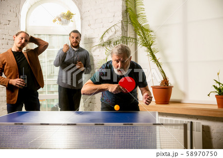 Young people playing table tennis in workplace, having fun 58970750