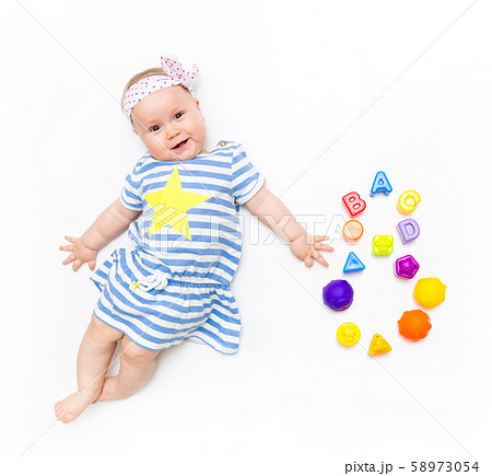 Portrait of a sweet infant baby girl wearing a pink dress and headband bow, isolated on white in 58973054