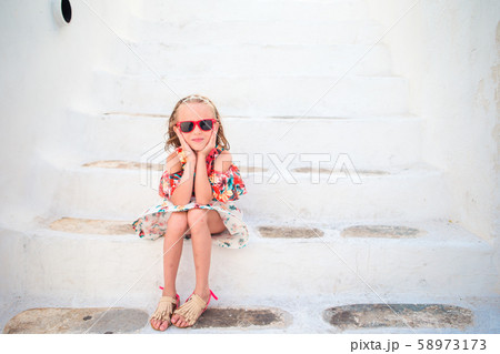 Girl in white dresses having fun outdoors on Mykonos streets 58973173