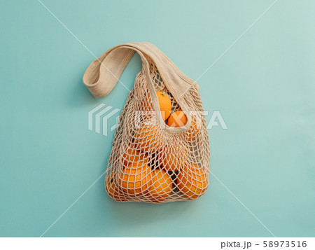 Mesh bag with fruits on blue background.Zero waste 58973516